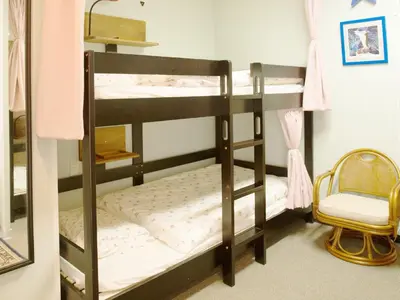 a bunk bed room with two bunk beds and a chair at Akasakano-sato(Premium) in Tokyo