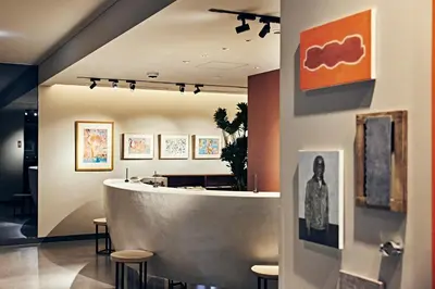 a lobby with a reception counter and stools at NOHGA HOTEL UENO TOKYO in Tokyo