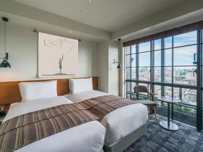 a hotel room with a bed and a large window at Ebisuholic Hotel in Tokyo
