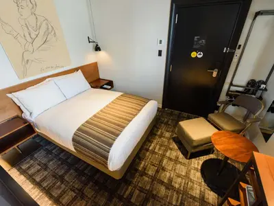 a bedroom with a bed and a desk and a chair at Ebisuholic Hotel in Tokyo