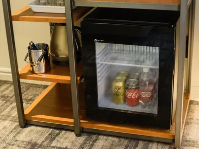 a small refrigerator with drinks inside of it at Ebisuholic Hotel in Tokyo