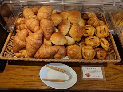 a tray of croissants and buns on a table at Ebisuholic Hotel in Tokyo