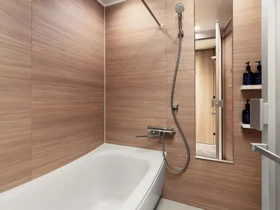 a bathroom with a tub and a shower with wooden walls at MIMARU Tokyo Ueno Inaricho in Tokyo