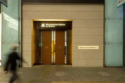 a person walking in front of a building at Marunouchi Hotel in Tokyo