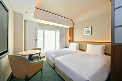 a hotel room with two beds and a table at Marunouchi Hotel in Tokyo