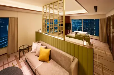 a living room with a couch and windows at Marunouchi Hotel in Tokyo
