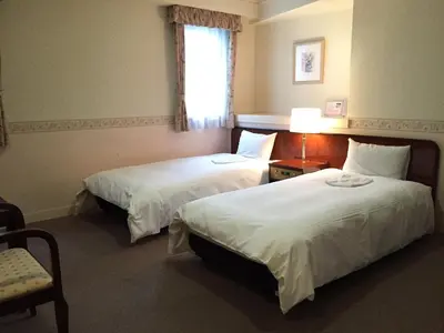a hotel room with two beds and a window at Ueno Terminal Hotel in Tokyo
