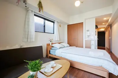 a bedroom with a large bed and a table at MIKO'S APT Iconic Shinjuku, lively Skyscraper view Tokyo, 10th fl, 3mins to Station 新宿 大久保のマンションで暮らす 駅チカ高層眺望 東京を楽しむ食べ歩き in Tokyo
