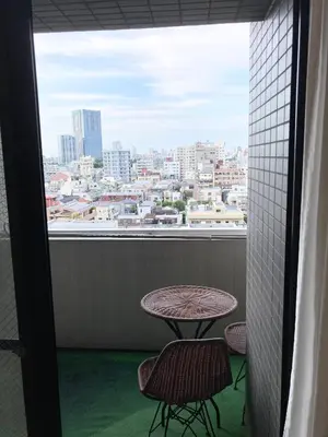 a balcony with a table and two chairs and a window at MIKO'S APT Iconic Shinjuku, lively Skyscraper view Tokyo, 10th fl, 3mins to Station 新宿 大久保のマンションで暮らす 駅チカ高層眺望 東京を楽しむ食べ歩き in Tokyo