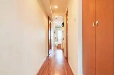 a hallway with a wooden floor in a room at MIKO'S APT Iconic Shinjuku, lively Skyscraper view Tokyo, 10th fl, 3mins to Station 新宿 大久保のマンションで暮らす 駅チカ高層眺望 東京を楽しむ食べ歩き in Tokyo