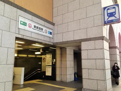 a woman walking into a building with a sign on it at MIKO'S APT Iconic Shinjuku, lively Skyscraper view Tokyo, 10th fl, 3mins to Station 新宿 大久保のマンションで暮らす 駅チカ高層眺望 東京を楽しむ食べ歩き in Tokyo