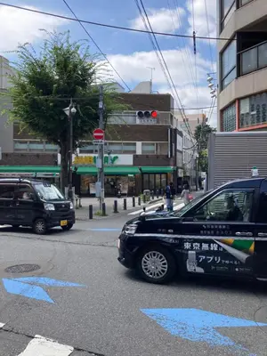 a black car is driving down a city street at MIKO'S APT Iconic Shinjuku, lively Skyscraper view Tokyo, 10th fl, 3mins to Station 新宿 大久保のマンションで暮らす 駅チカ高層眺望 東京を楽しむ食べ歩き in Tokyo