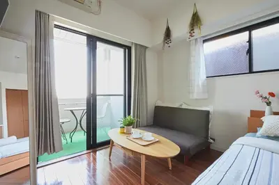 a living room with a couch and a table at MIKO'S APT Iconic Shinjuku, lively Skyscraper view Tokyo, 10th fl, 3mins to Station 新宿 大久保のマンションで暮らす 駅チカ高層眺望 東京を楽しむ食べ歩き in Tokyo