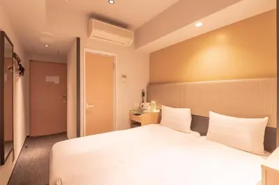 a hotel room with a large bed in a room at E Hotel Higashi Shinjuku in Tokyo