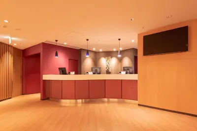 a hotel lobby with a bar and a flat screen tv at E Hotel Higashi Shinjuku in Tokyo