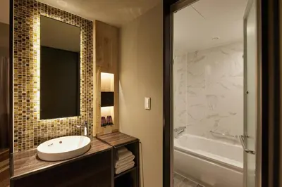 a bathroom with a sink and a tub and a mirror at SHIBUYA STREAM HOTEL formerly Shibuya Stream Excel Hotel Tokyu in Tokyo