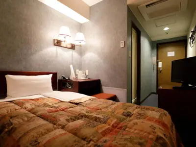 a bedroom with a large bed and a television at Tokyo Inn in Tokyo