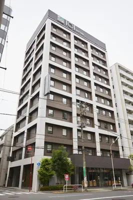 a large building with a sign on top of it at ICI HOTEL Ueno Shin Okachimachi in Tokyo