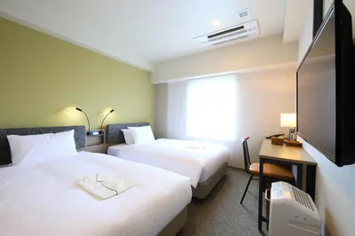 a hotel room with two beds and a television at ICI HOTEL Ueno Shin Okachimachi in Tokyo