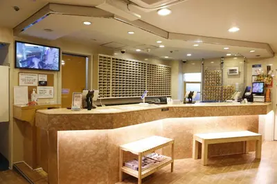 a restaurant with a large counter with two stools at Shinjuku Kuyakusho-mae Capsule Hotel in Tokyo