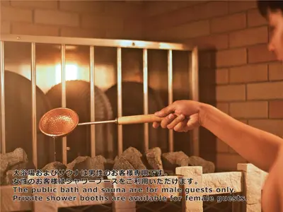 a person is cooking food in an oven at Shinjuku Kuyakusho-mae Capsule Hotel in Tokyo
