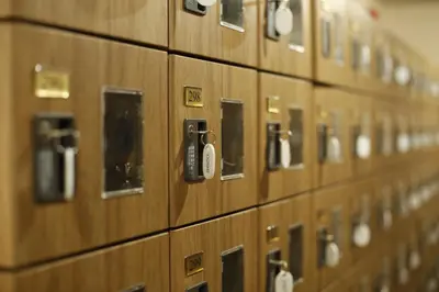 a row of wooden lockets withiazepines on them at Shinjuku Kuyakusho-mae Capsule Hotel in Tokyo