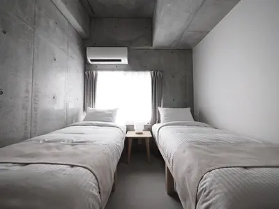 two beds in a room with a window at Smi:re Stay Oshiage in Tokyo
