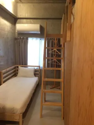 a bunk bed and a ladder in a room at Smi:re Stay Oshiage in Tokyo