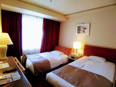 a hotel room with two beds and a window at Tokyo Grand Hotel in Tokyo