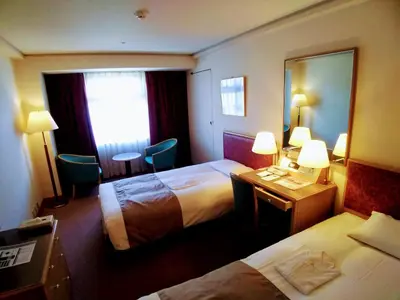 a hotel room with two beds and a mirror at Tokyo Grand Hotel in Tokyo