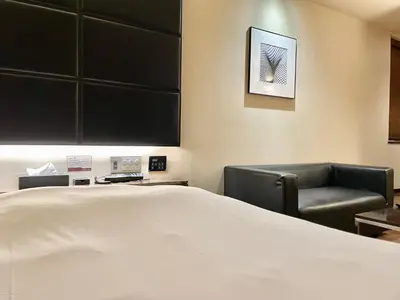 a hotel room with a bed and a chair at Hotel BIX \u30c1\u30a7\u30c3\u30af\u30a4\u30f323\u6642 \u5909\u66f4\u4e0d\u53ef in Tokyo