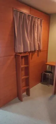 a room with a bed with a window and a shelf at Ace Inn Shinjuku in Tokyo