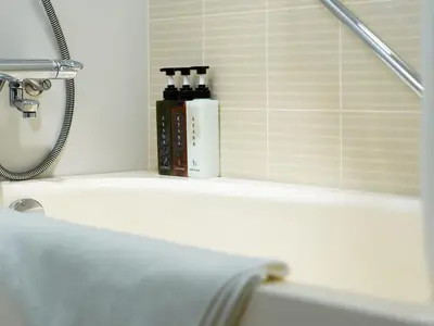 a shelf with two bottles ofodorizers on top of a bath tub at Mitsui Garden Hotel Shiodome Italia-gai - Tokyo in Tokyo