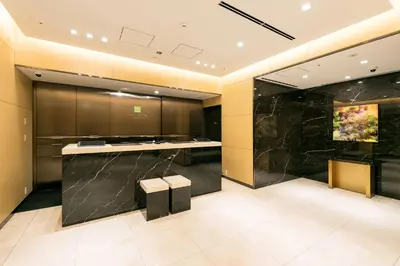 a kitchen with black marble counter and a stool at Ginza Capital Hotel Moegi in Tokyo