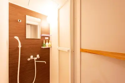 a shower in a bathroom with a door open at plat hostel keikyu asakusa station in Tokyo