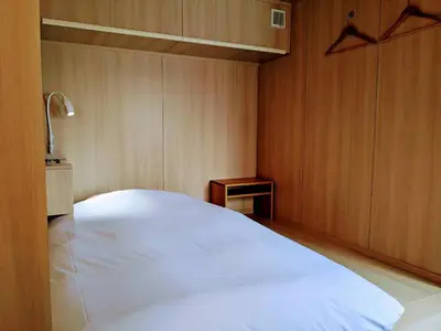 a bedroom with a large white bed and a table at plat hostel keikyu asakusa station in Tokyo