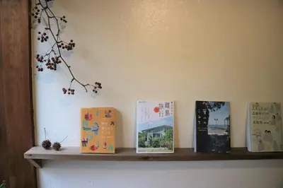 a shelf with four books on a wall at Komatsuya in Tokyo