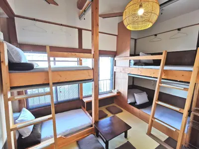 a room with four bunk beds and a table at Komatsuya in Tokyo