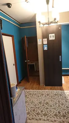 a living room with blue walls and a black door at GUEST HOUSE SaKURa in Tokyo