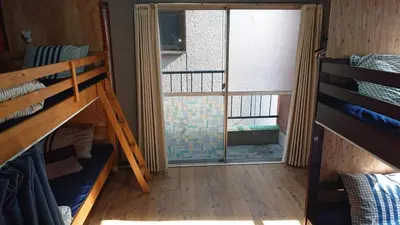 a room with bunk beds and a large window at GUEST HOUSE SaKURa in Tokyo