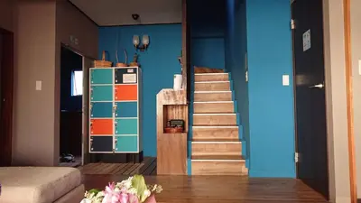 a room with a staircase and a blue wall at GUEST HOUSE SaKURa in Tokyo