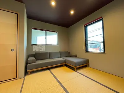 a waiting room with a couch and two windows at COTO Tokyo Asakusa 5 in Tokyo
