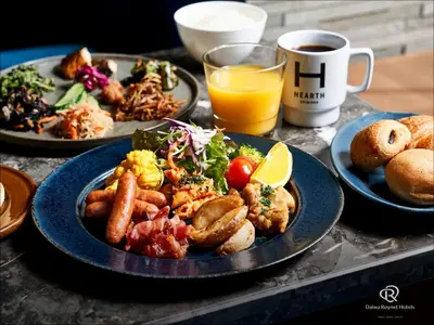 a table with plates of food and a cup of coffee at Daiwa Roynet Hotel Nishi-Shinjuku PREMIER in Tokyo