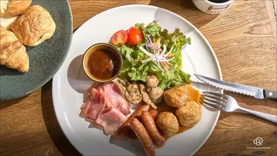 a plate of food with meat and salad and bread at Daiwa Roynet Hotel Nishi-Shinjuku PREMIER in Tokyo