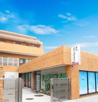 a brick building with a sign on the side of it at Shinjuku Sky hostel in Tokyo