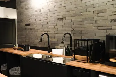 a kitchen with two sinks and a brick wall at waves nakameguro in Tokyo
