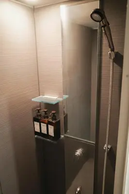 a bathroom with a shower with a glass door at waves nakameguro in Tokyo