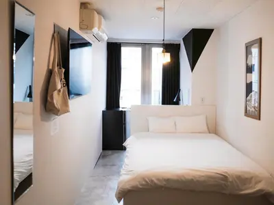 a small bedroom with a bed in a room at waves nakameguro in Tokyo