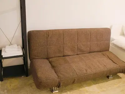 a brown couch in a living room with a table at waves nakameguro in Tokyo