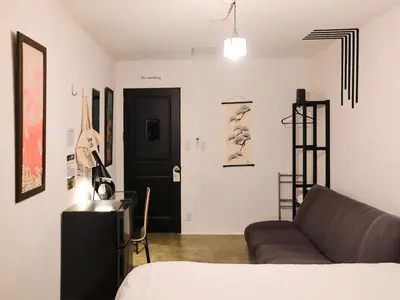 a living room with a couch and a black door at waves nakameguro in Tokyo